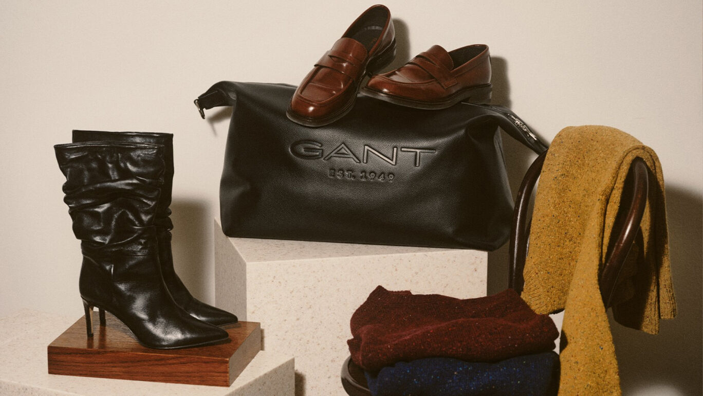 Leather brown bag, cap, knits and shoes on a chair