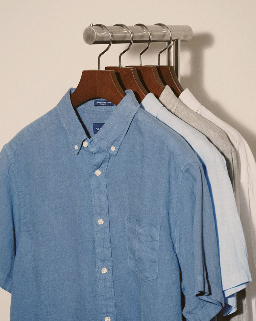 Four linen shirts hanging on a rack